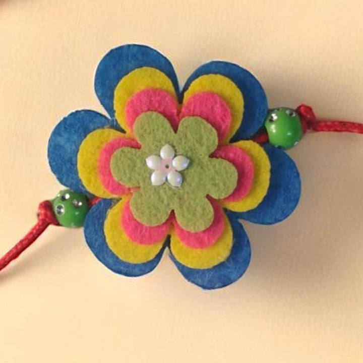 Handmade Beaded Flower Theme Pom Pom Felt Rakhi With Roli Chawal For Kids - Close-up Front View