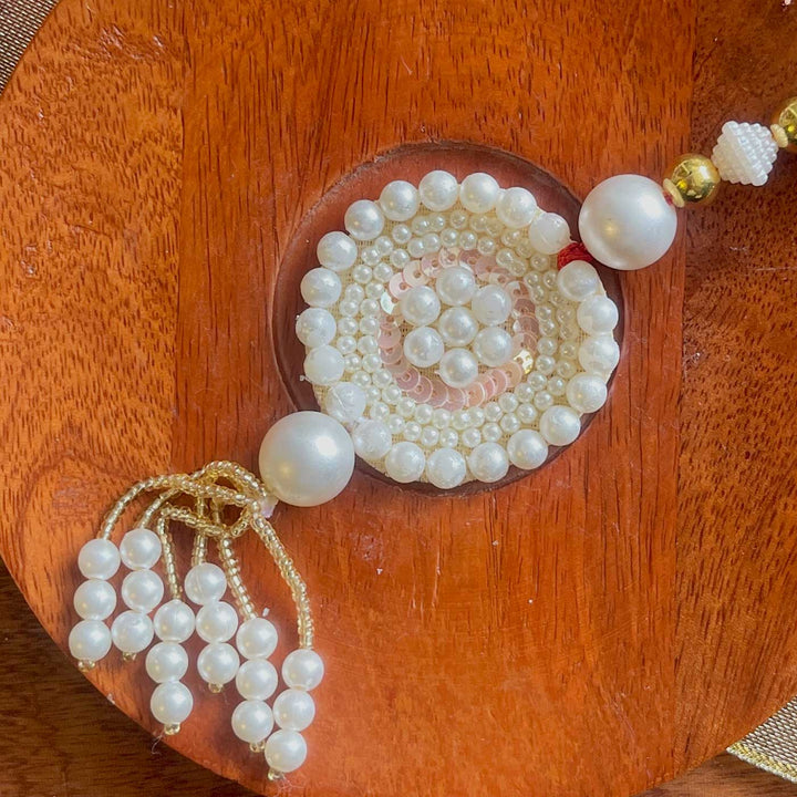 Handmade White Flower Design Pearl And Stone Bhaiya Bhabhi Rakhi - Close-up of Pearl Tassel Detail