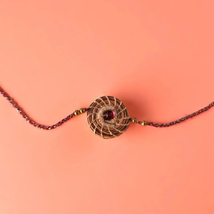 Eco Friendly Handmade Silver And Red Pine Needle Rakhi With Pouch And Roli Chawal - Flat Lay Centered View