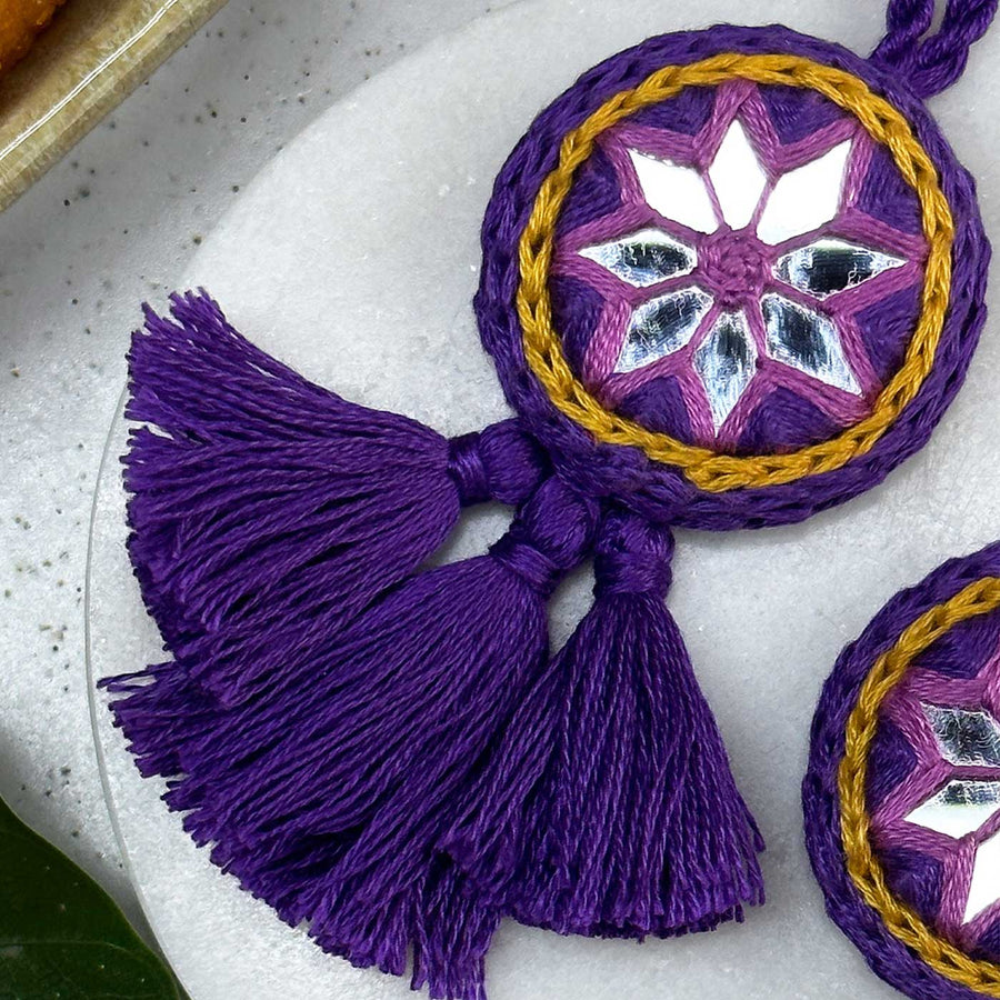 Customized Handmade Mirror Work Cotton Lumba Rakhi For Bhabhi With Roli Chawal - Close-up of Purple Tassel Detail