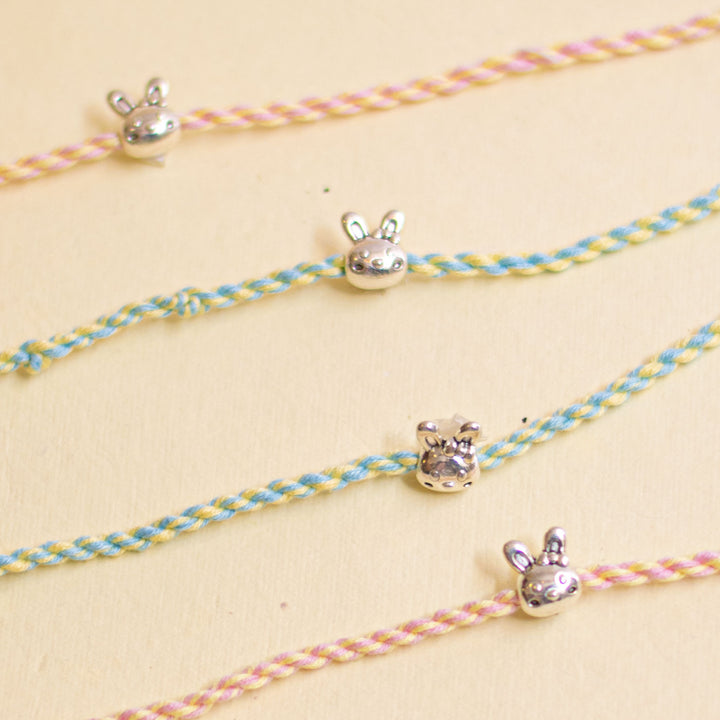 Handmade Silver Bunny Design Kids Rakhi With Roli Chawal - Close-up of charms with cord texture