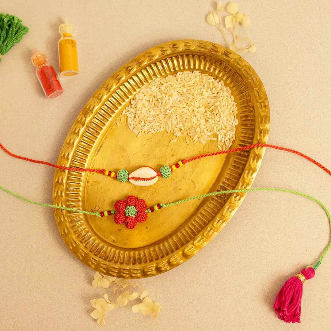 Handmade Crochet Phool Kaudi Rakhi With Roli Chawal Set Of 2 - Flat lay with full Rakhi strings