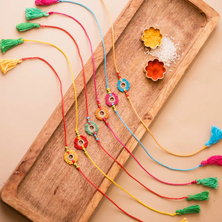 Handmade Crochet Rainbow Flowers Rakhi With Roli Chawal Set Of 6 - Top View with Tassels Shown