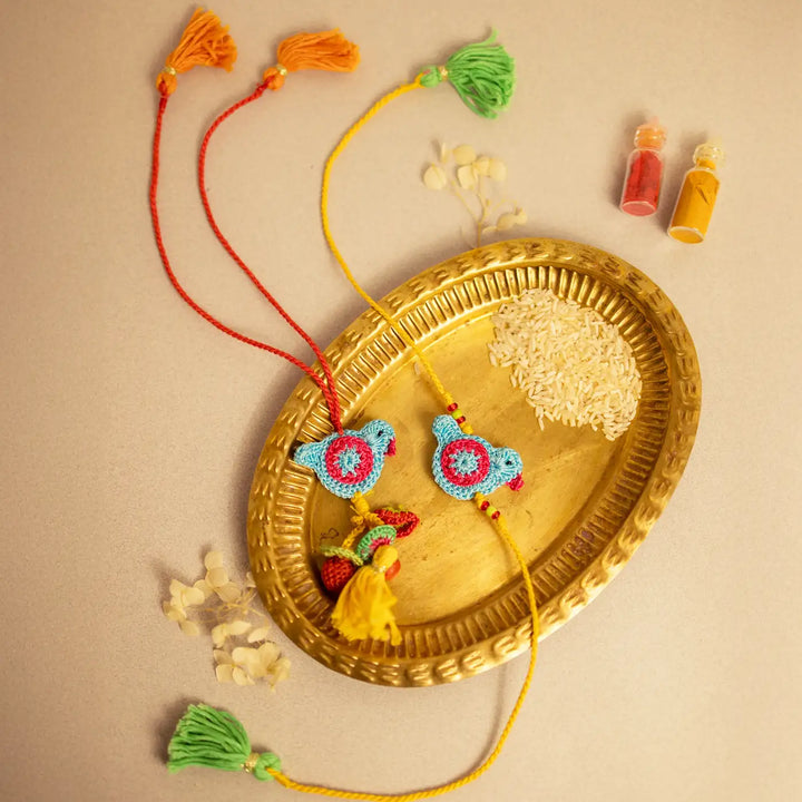 Handmade Crochet Blue Birds Bhaiya Bhabhi Rakhi With Roli Chawal Set Of 2 - Arranged on decorative brass tray