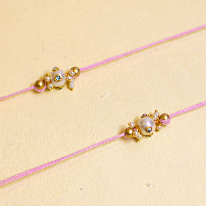 Handmade Basra Pearl Rakhi With Roli Chawal - Detailed close-up of pink bracelets