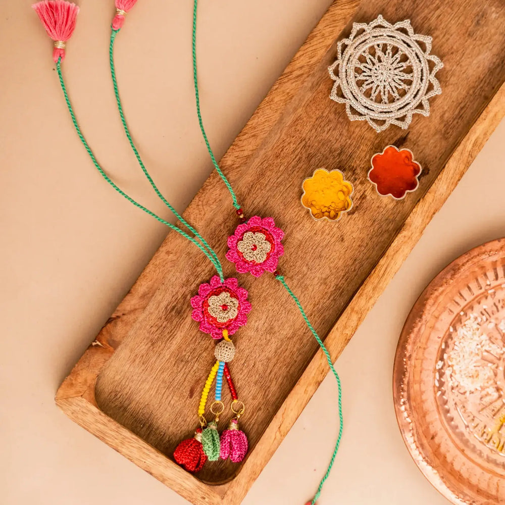 Handmade Crochet Pink Bougainvillea Bhaiya Bhabhi Rakhi With Roli Chawal Set Of 2 - Full View with Decorative Items