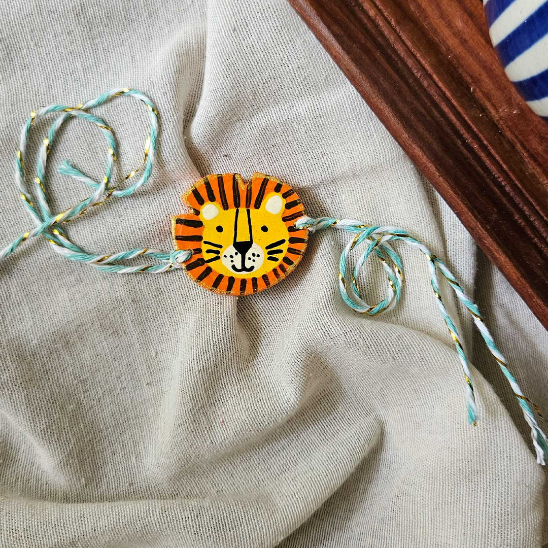 Handpainted Quirky Wooden Rakhi With Roli Chawal 14 - Close-up of single rakhi with string