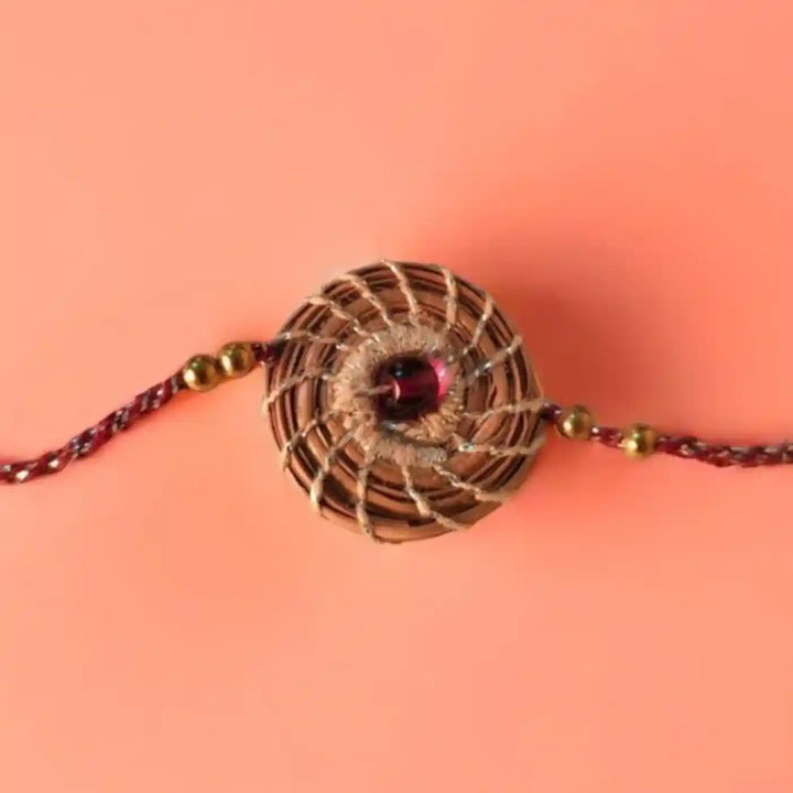 Eco Friendly Handmade Silver And Red Pine Needle Rakhi With Pouch And Roli Chawal - Flat Lay Top View
