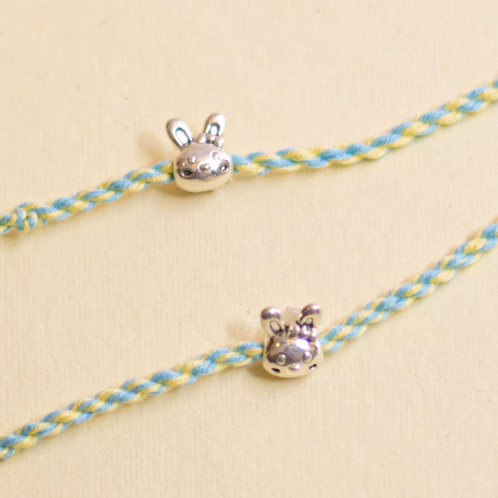 Handmade Silver Bunny Design Kids Rakhi With Roli Chawal - Detail view of two charm designs