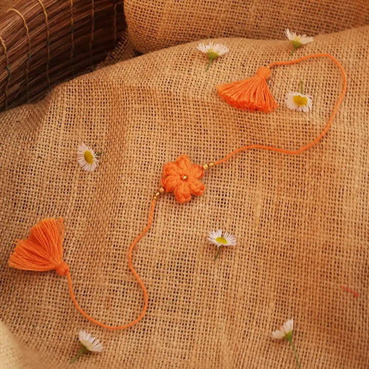 Handmade Crochet Blue Flower Rakhi With Roli Chawal - Orange Threaded Flower on Burlap