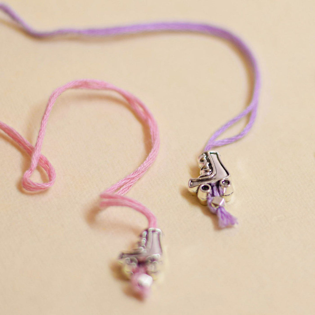 Handmade Stake Board Shoe And Pearl Design Rakhi With Roli Chawal - Pink and purple charm ends