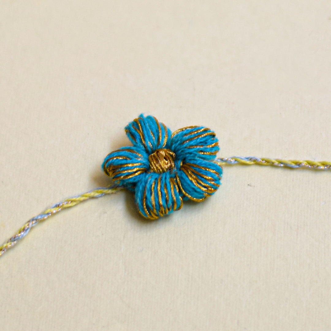 Handmade Crochet Flower And Ghungroo Design Bhaiya Bhabhi Rakhi With Roli Chawal - Single blue floral bracelet close-up