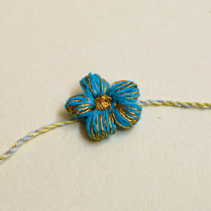 Handmade Crochet Flower And Ghungroo Design Bhaiya Bhabhi Rakhi With Roli Chawal - Single blue floral bracelet close-up