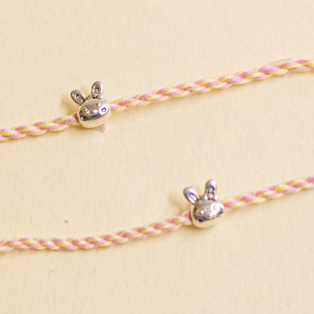 Handmade Silver Bunny Design Kids Rakhi With Roli Chawal - Close-up of charms on pink cords