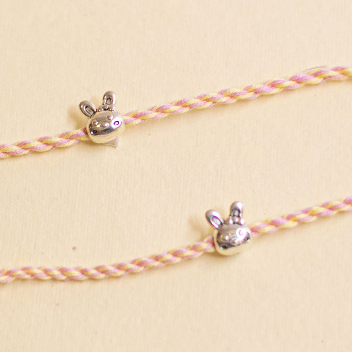 Handmade Silver Bunny Design Kids Rakhi With Roli Chawal - Close-up of charms on pink cords