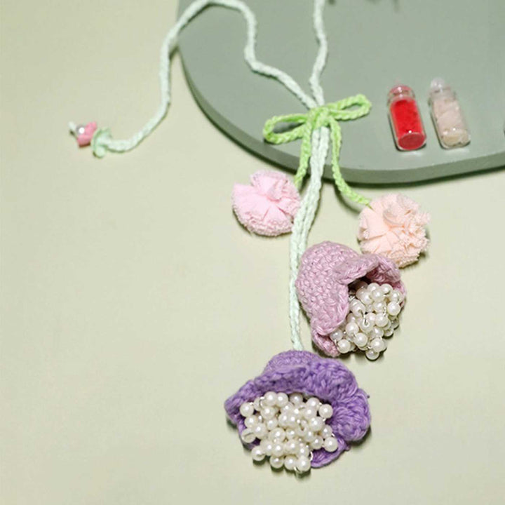 Handmade Crochet Forever Flowers Kids Rakhi With Roli Chawal Copy - Close-up of purple crochet flower necklace