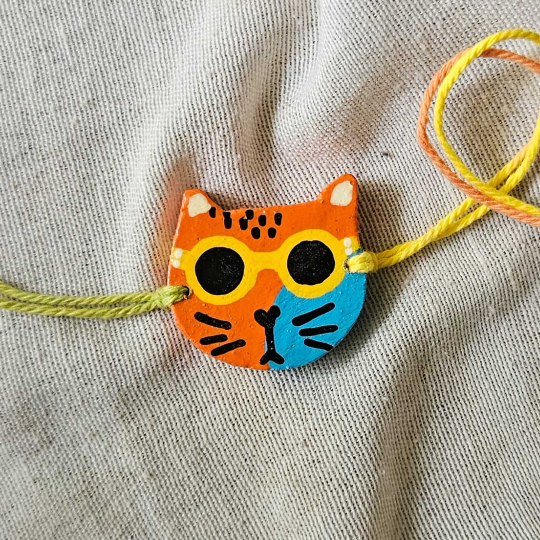 Handpainted Quirky Wooden Rakhi With Roli Chawal 16 - Close-up of single cat bracelet (5)