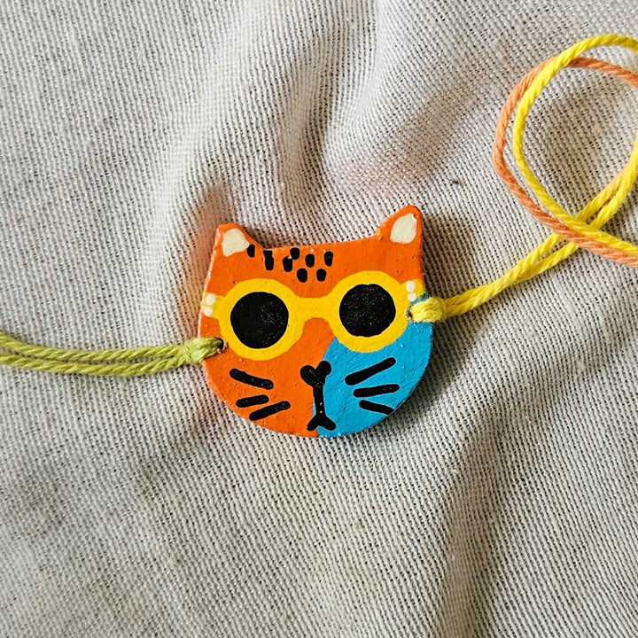 Handpainted Quirky Wooden Rakhi With Roli Chawal 16 - Close-up of single cat bracelet (5)