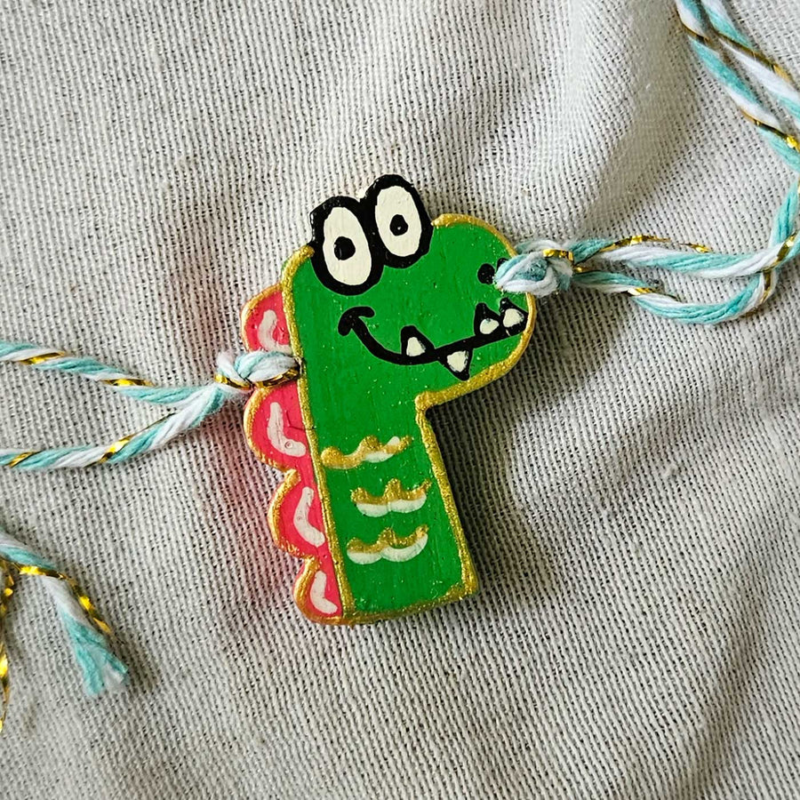 Handpainted Quirky Wooden Rakhi With Roli Chawal 17 - Close-up of Green Dino Bracelet