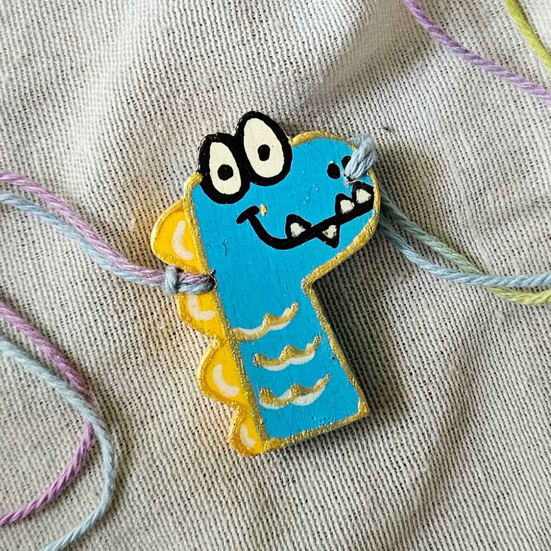 Handpainted Quirky Wooden Rakhi With Roli Chawal 17 - Close-up of Blue Dino Bracelet