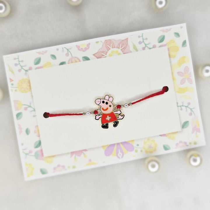 Handmade Peppa Pig Theme Metal Kids Rakhi With Roli Chawal - Bracelet Displayed in Packaging Card