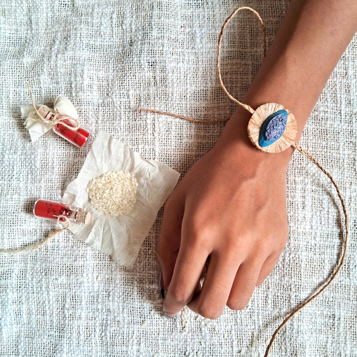 Handmade Papier Mache Naquashi Blue Rakhi With Roli Chawal - Worn on wrist display