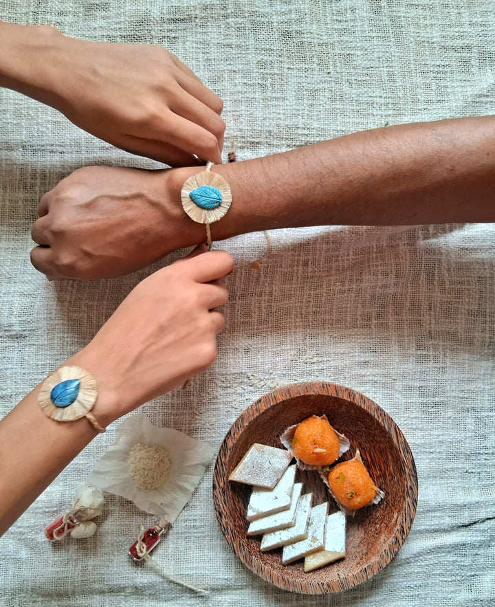 Handmade Papier Mache Yellow And Blue Leaf Rakhi With Roli Chawal Set Of 2 - Bracelets Worn on Wrists