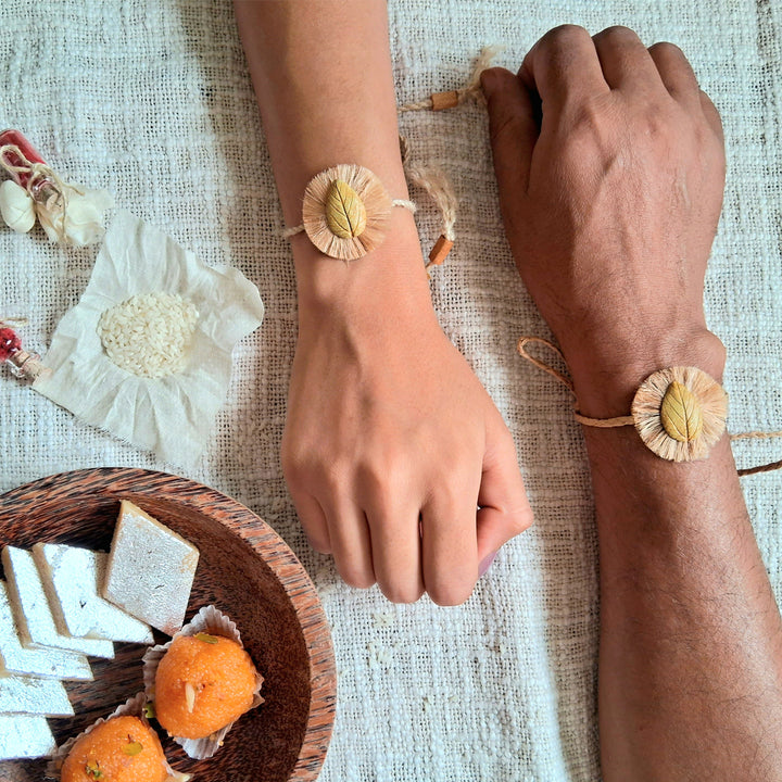 Handmade Papier Mache Yellow And Blue Leaf Rakhi With Roli Chawal Set Of 2 - Bracelets on Wrists with Sweets