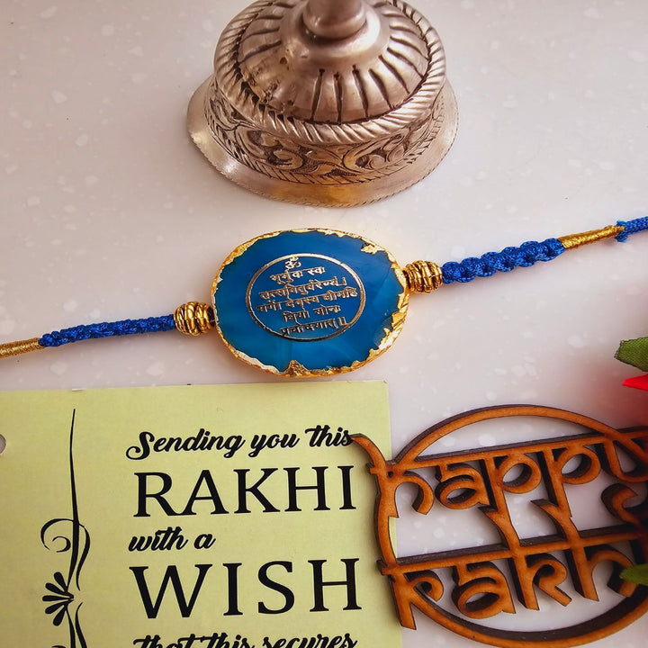 Handmade Gayatri Mantra Agate Rakhi With Roli Chawal For Brother - Close-up of Blue Rakhi and Card