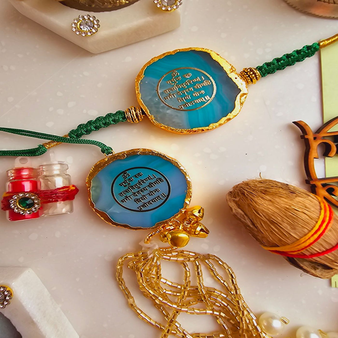 Handmade Gayatri Mantra Agate Bhaiya Bhabhi Rakhi With Roli Chawal - Close-up of blue Rakhi pair with accessories