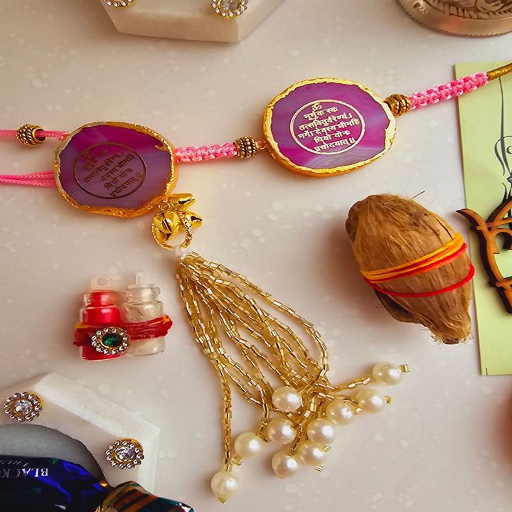 Handmade Gayatri Mantra Agate Bhaiya Bhabhi Rakhi With Roli Chawal - Close-up of pink Rakhi pair with accessories