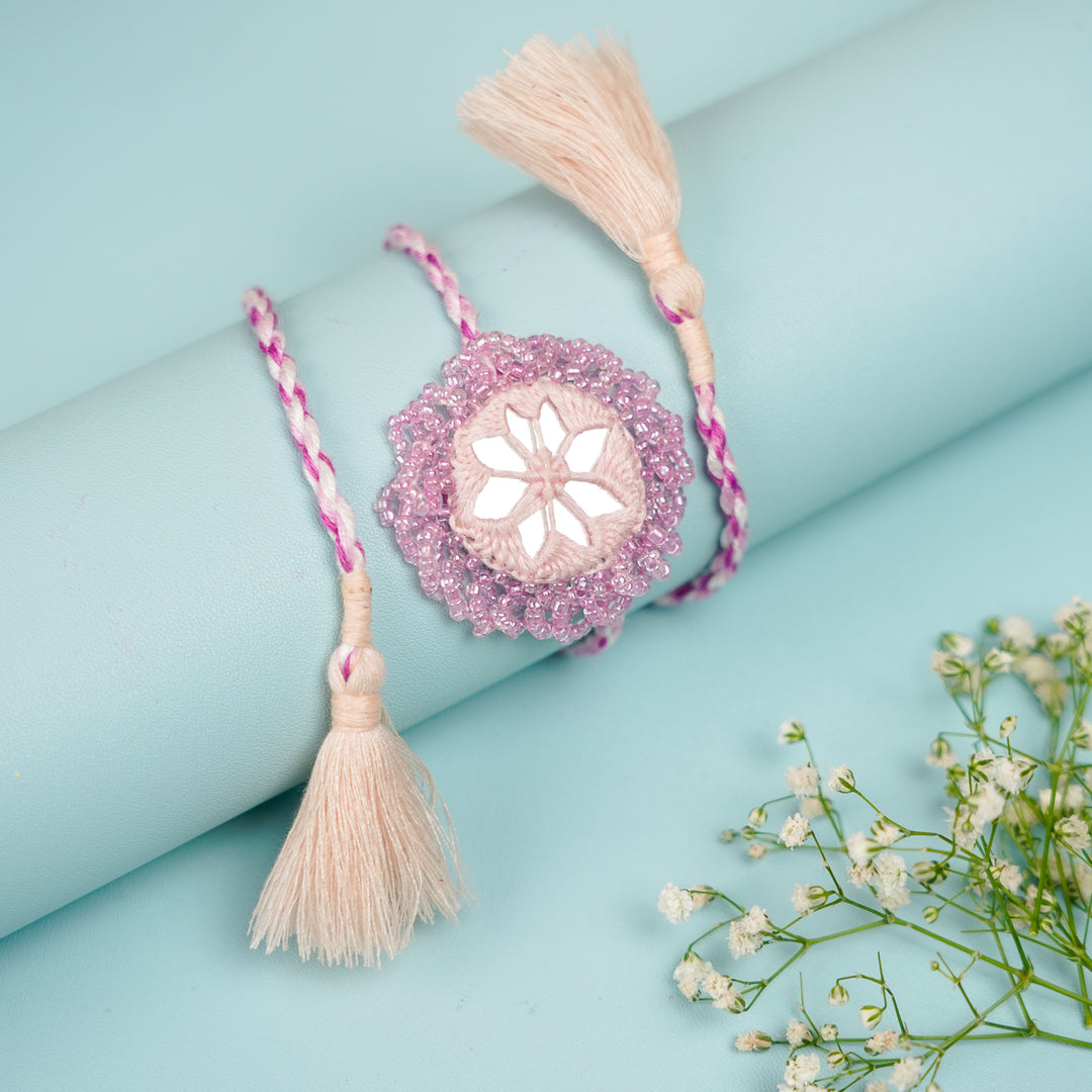 Handmade Reusable Lavender Mirror And Jhumki Rakhi For Bhaiya And Bhabhi - Close-up on Rolled Display Surface