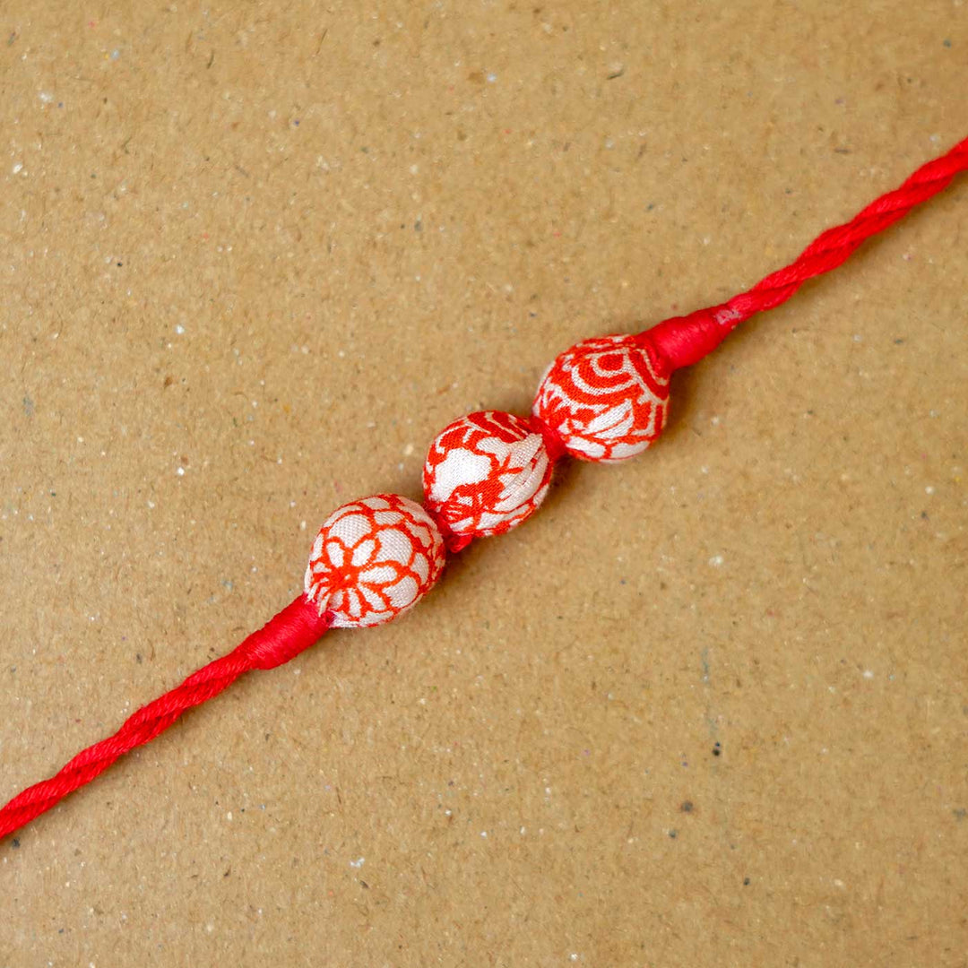 Handmade Red Upcycled Fabric Rakhi With Roli Chawal - Close-up of Rakhi beads