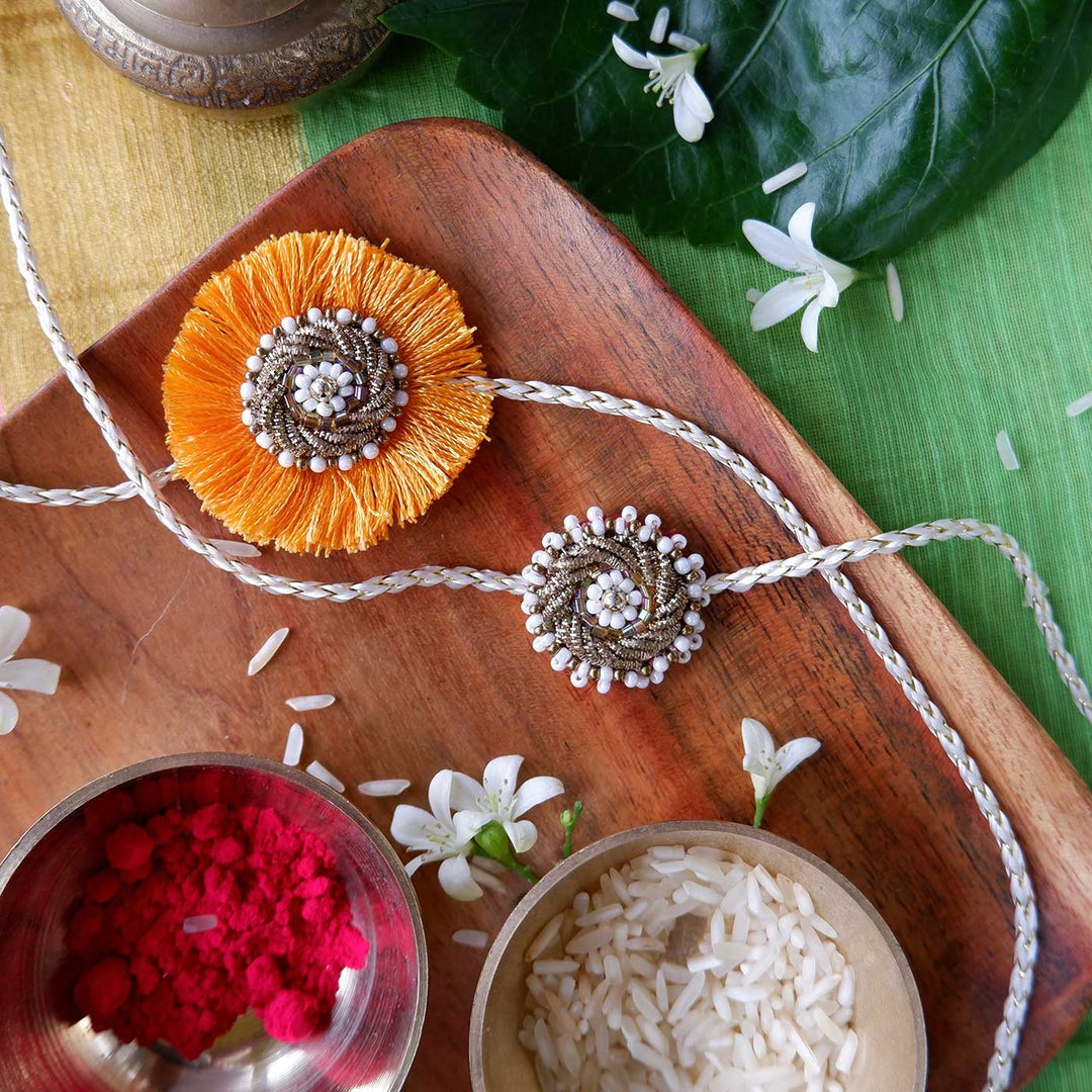 Handmade Zardozi Mustard And White Bead Work Bhaiya Bhabhi Rakhi With Wooden Box And Roli Chawal Set Of 2 - Laid Flat on Tray