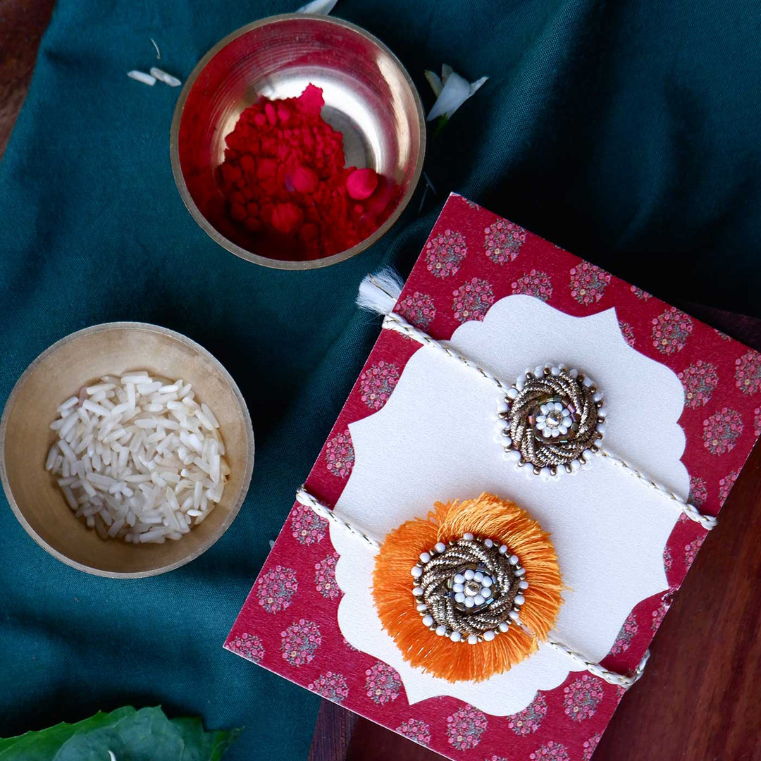Handmade Zardozi Mustard And White Bead Work Bhaiya Bhabhi Rakhi With Wooden Box And Roli Chawal Set Of 2 - Displayed with Red Gift Box