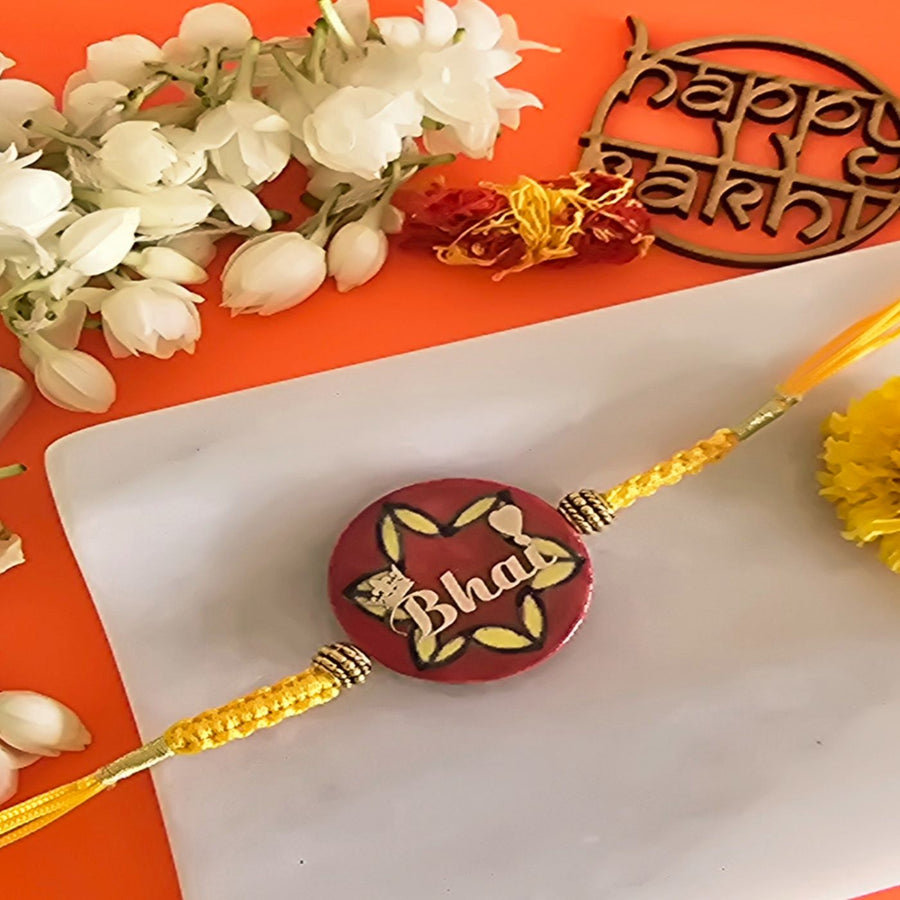 Handmade Laser Cut Red Bhai Ceramic Rakhi With Roli Chawal For Brother - Rakhi Close-up with Decorative Flowers