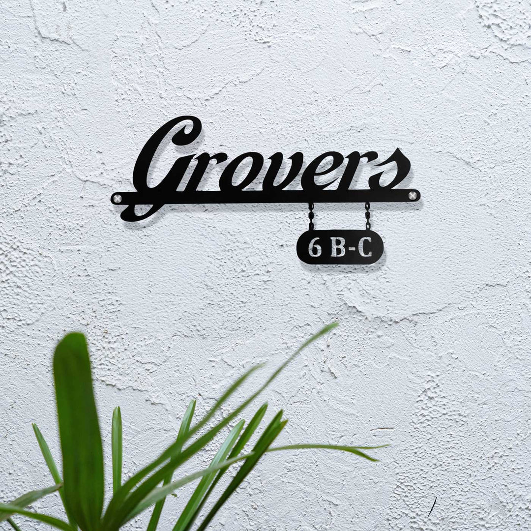 Personalized Waterproof Sleek Black Metal Name Plate - Mounted on Exterior Wall with Plant