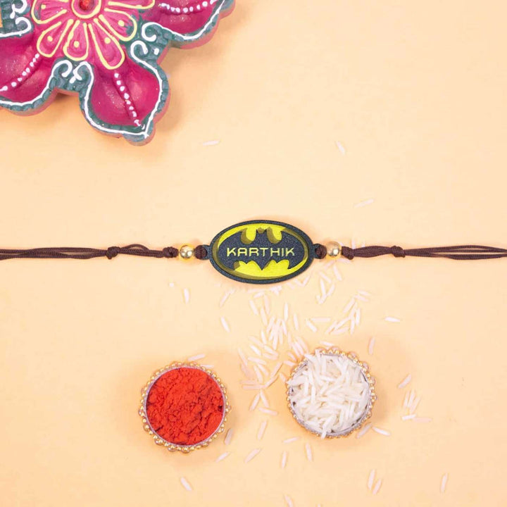 Personalized Handmade Batman Logo Wooden Kids Rakhi With Roli Chawal - Flat Lay with Rakhi and Ritual Items