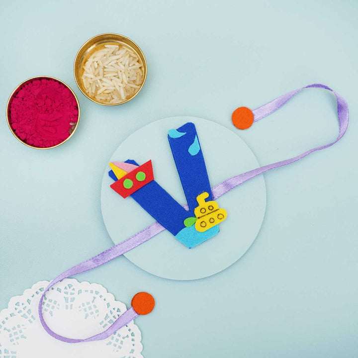 Personalised Handmade Boat Felt Rakhi With Chocolates Roli Chawal - Blue V Rakhi with Holi Items Flat Lay