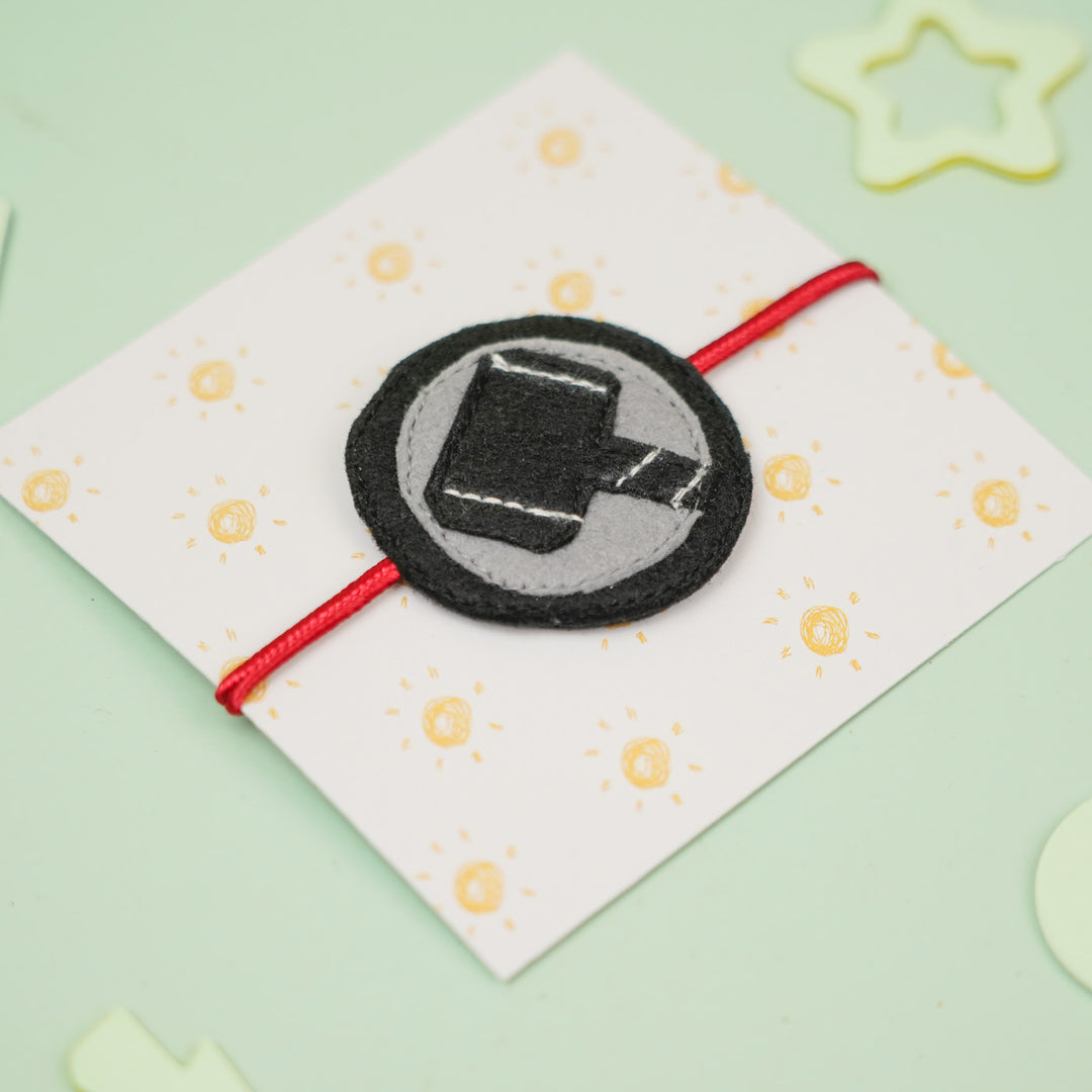 Handmade Thor Hammer Theme Felt Kids Rakhi For Brother - Bracelet on Patterned Card Close-up