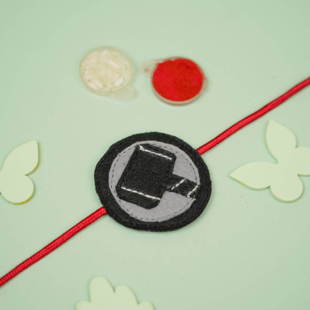 Handmade Thor Hammer Theme Felt Kids Rakhi For Brother - Styled Flat Lay with Accessories