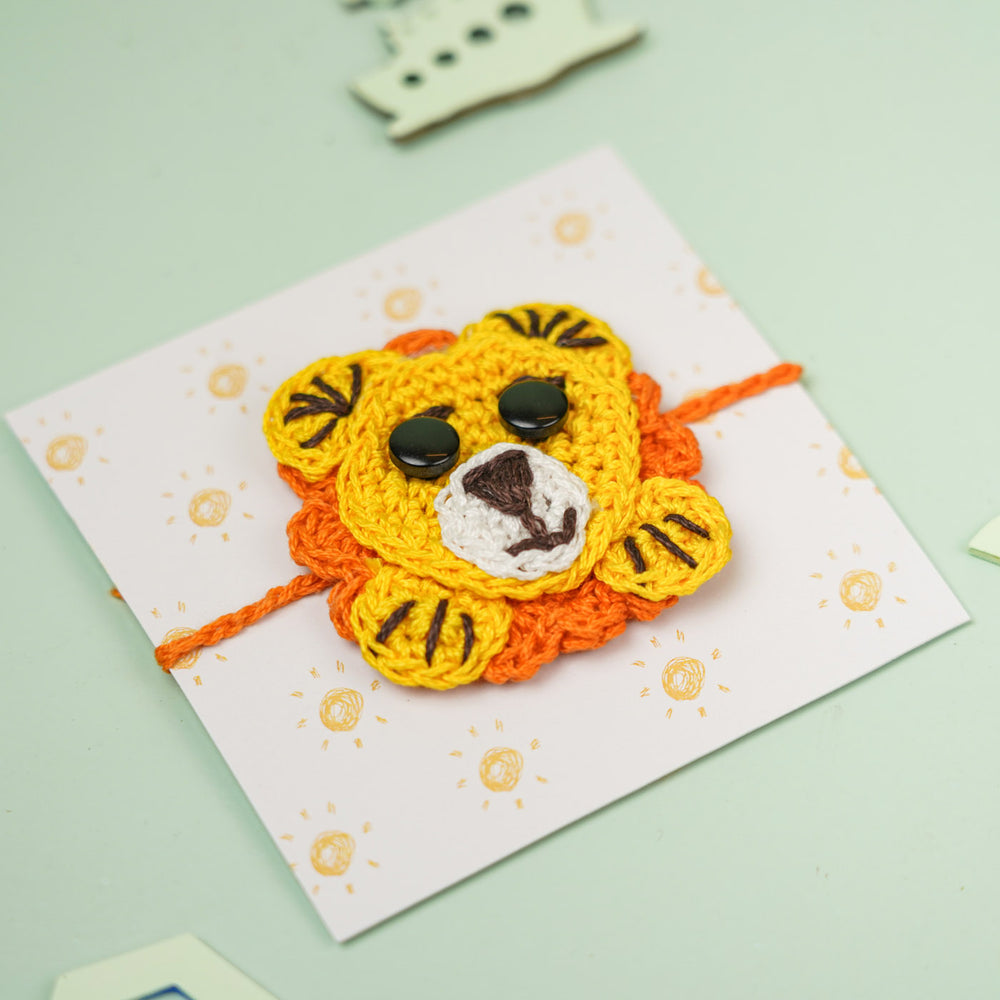 Handmade Crochet Lion Design Kids Rakhi With Roli Chawal - Angled Close-up on Card