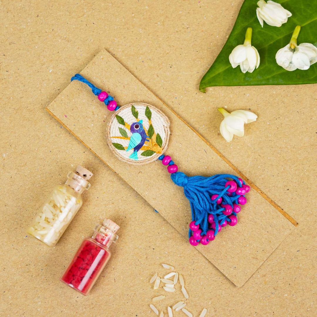 Handmade Pressed Flower Art Bluebird Jute Lumba Rakhi For Bhabhi With Roli Chawal - Flat Lay with Decorative Items