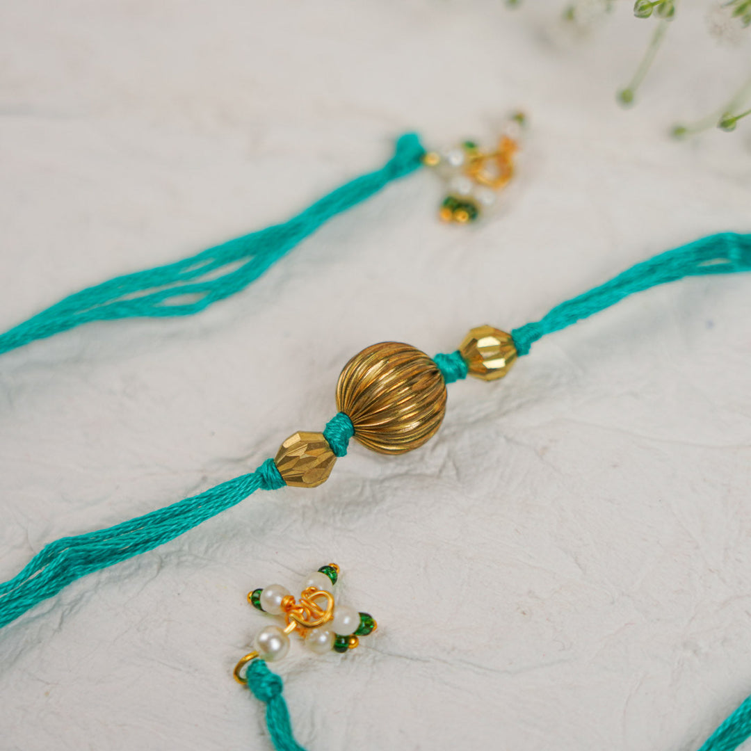 Handmade Swarn Pearl And Ghungroo Rakhi With Roli Chawal - Close-up of central beads