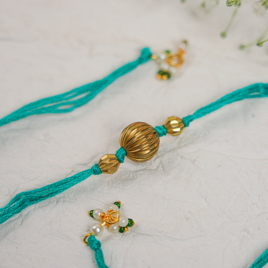Handmade Swarn Pearl And Ghungroo Rakhi With Roli Chawal - Close-up of central beads