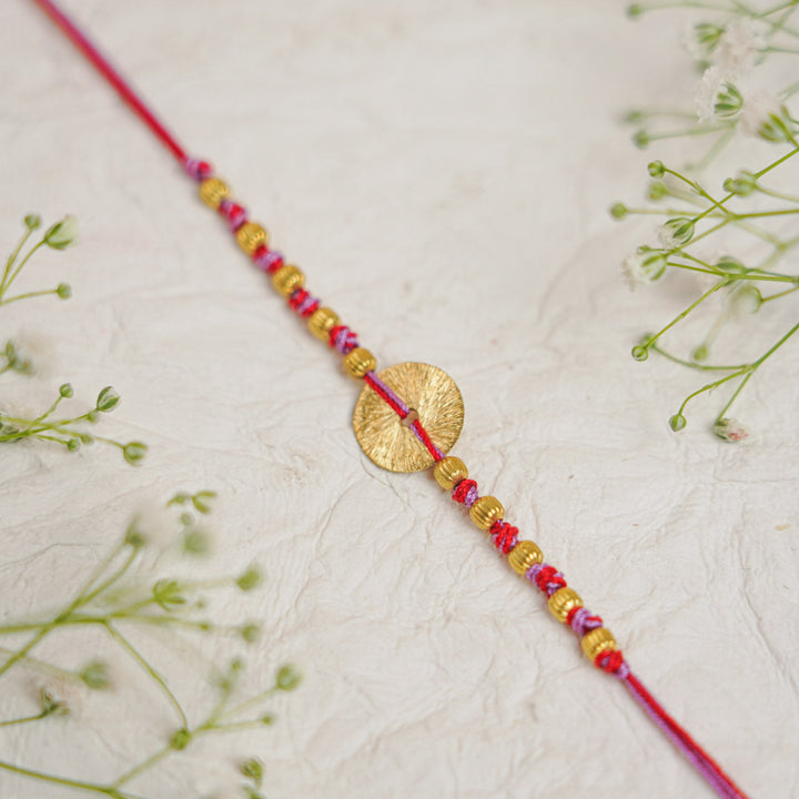 Handmade Swarn Sutra Ghungroo Bhaiya Bhabhi Rakhi With Roli Chawal - Close-up of Circle Detail Red