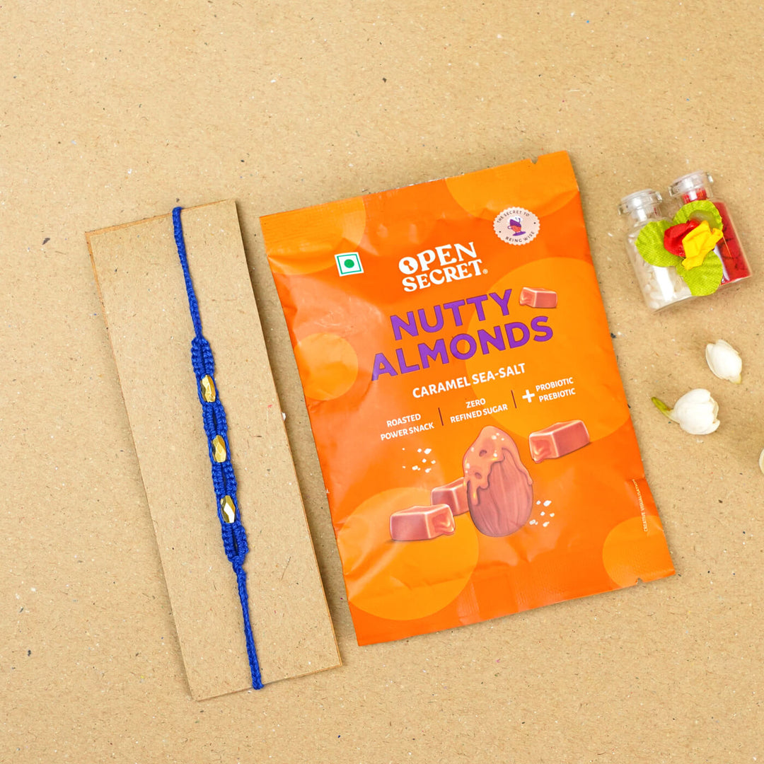 Handmade Macrame Three Gold Beaded Rakhi With Roli Chawal - Displayed on Card with Packaged Snack