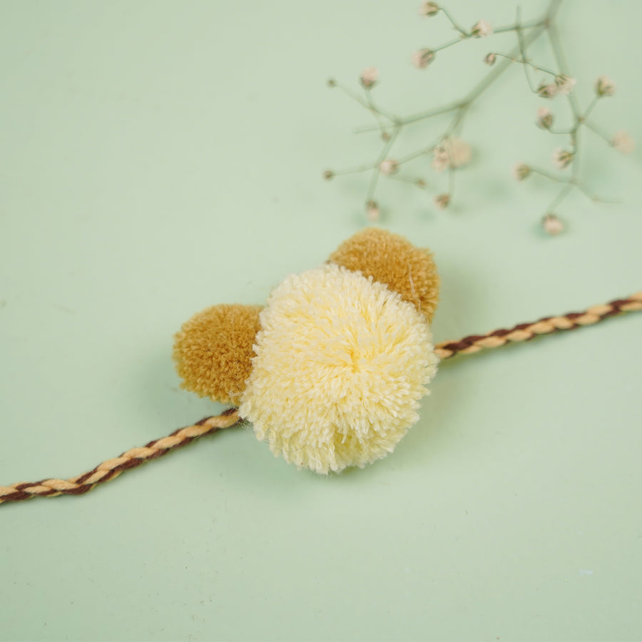 Handmade Pom Pom Teddy Design Kids Rakhi With Roli Chawal - Close-up on Yellow Pom-Pom Bracelet