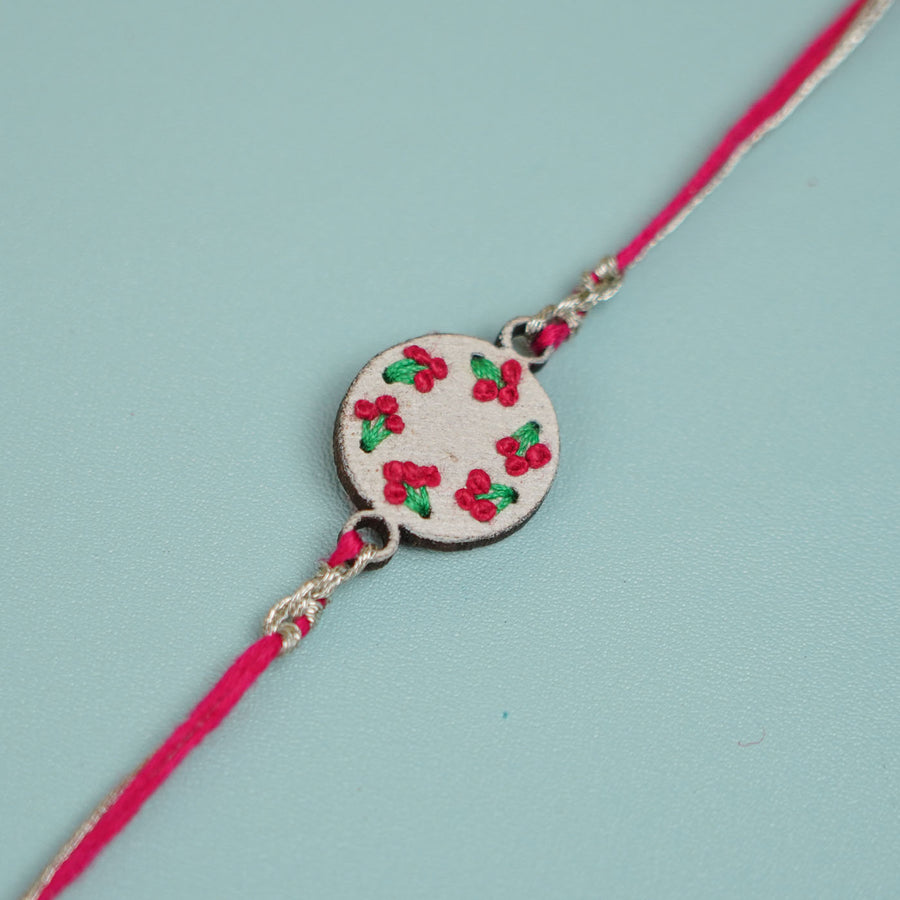 Handmade Pink Knot Design Wooden Rakhi With Roli Chawal For Brother - Close-up of Embroidered Charm