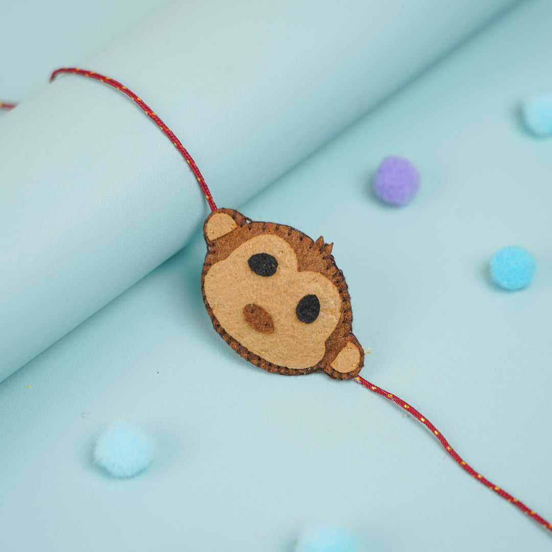 Handmade Beaded Monkey Theme Pom Pom Felt Rakhi With Roli Chawal For Kids - Close-up of Bracelet Charm